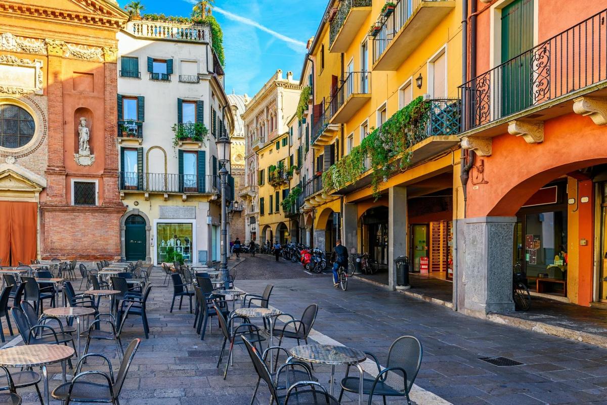 an empty street with tables and chairs and buildings
