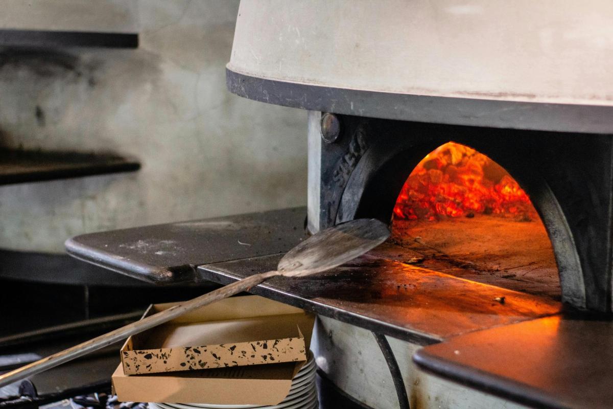 a kitchen with a pizza oven with a spatula