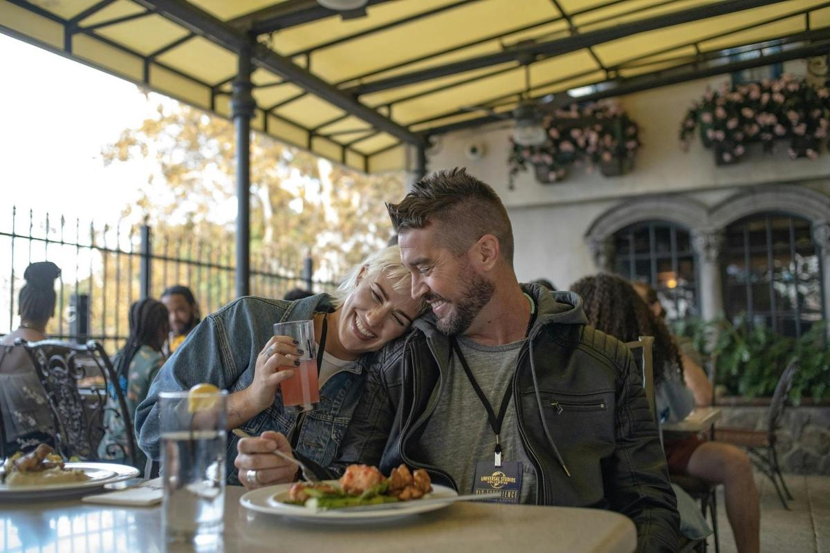 a man and woman sitting at a table with a plate of food
