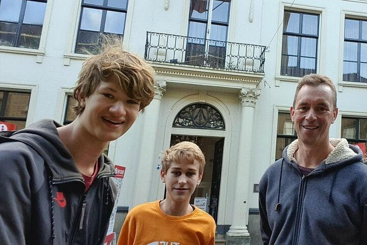 three young men standing in front of a building