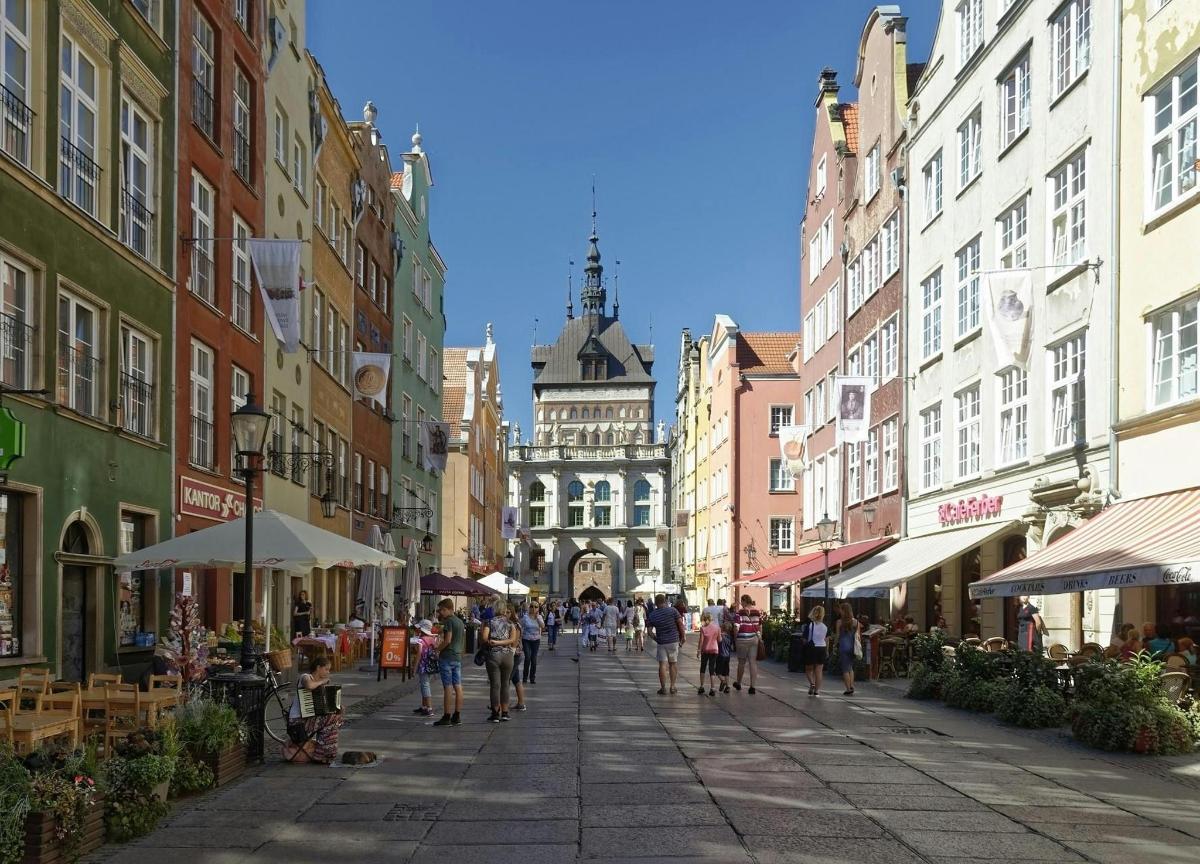 a group of people walking down a street with buildings