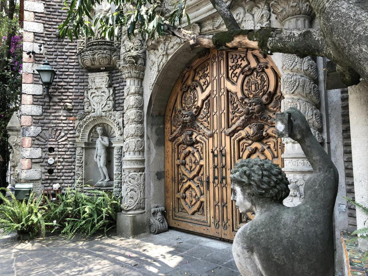 a statue in front of a large wooden door
