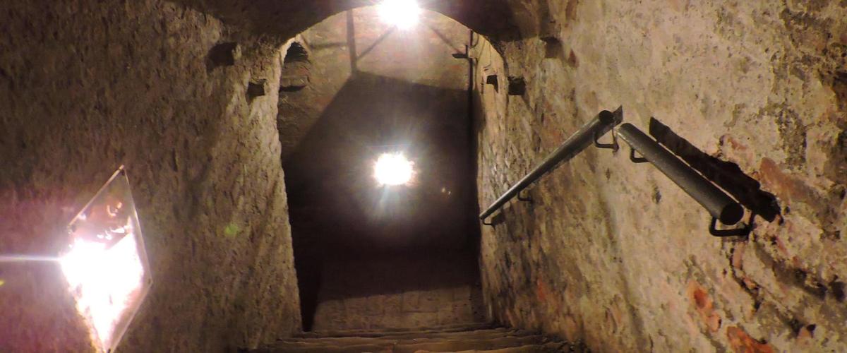 a dark hallway with a light at the end of a tunnel