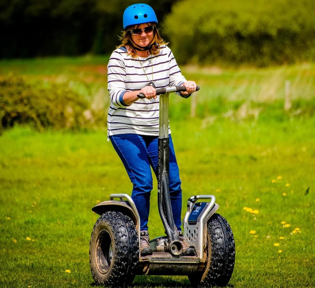 a woman in a helmet riding a toy electric vehicle
