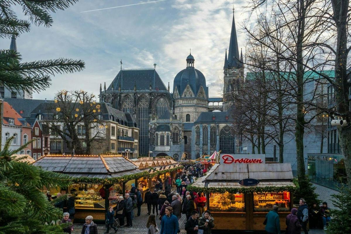 a group of people walking around a christmas market