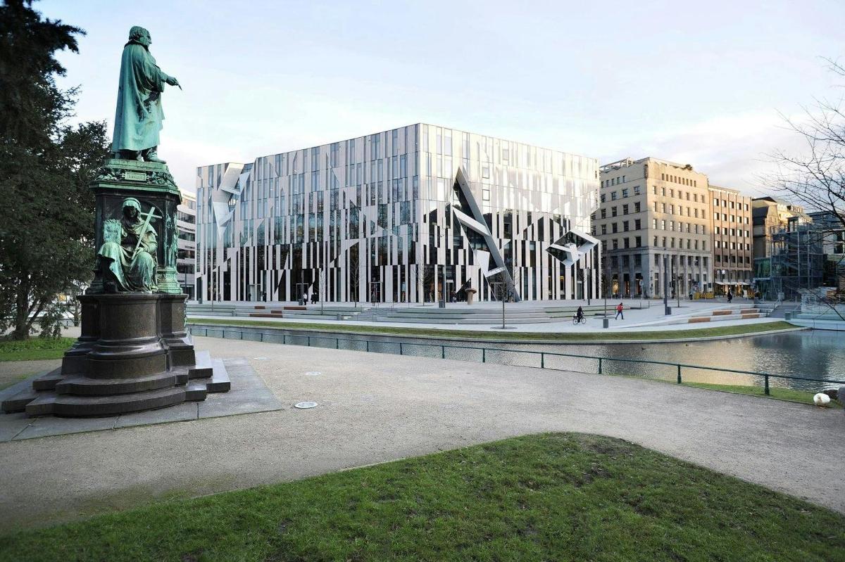 a statue of a man on a pedestal in front of a building