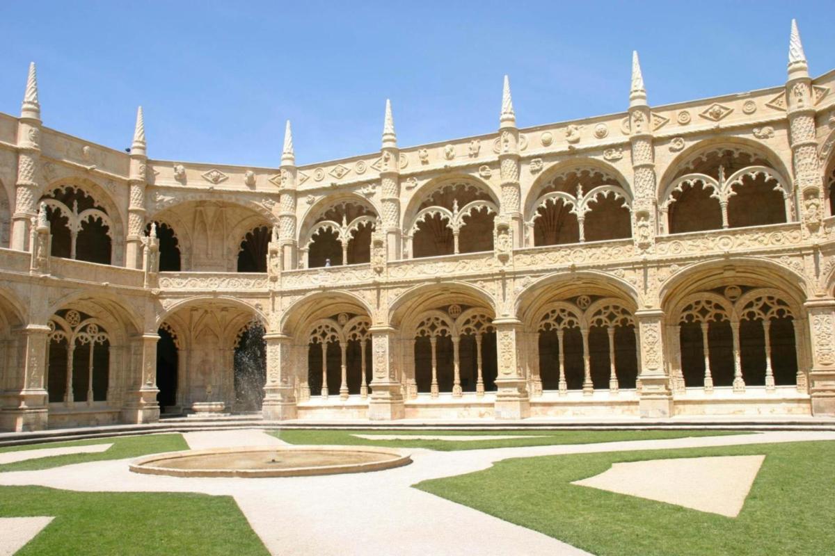 un gran edifici amb un pati amb gespa verda