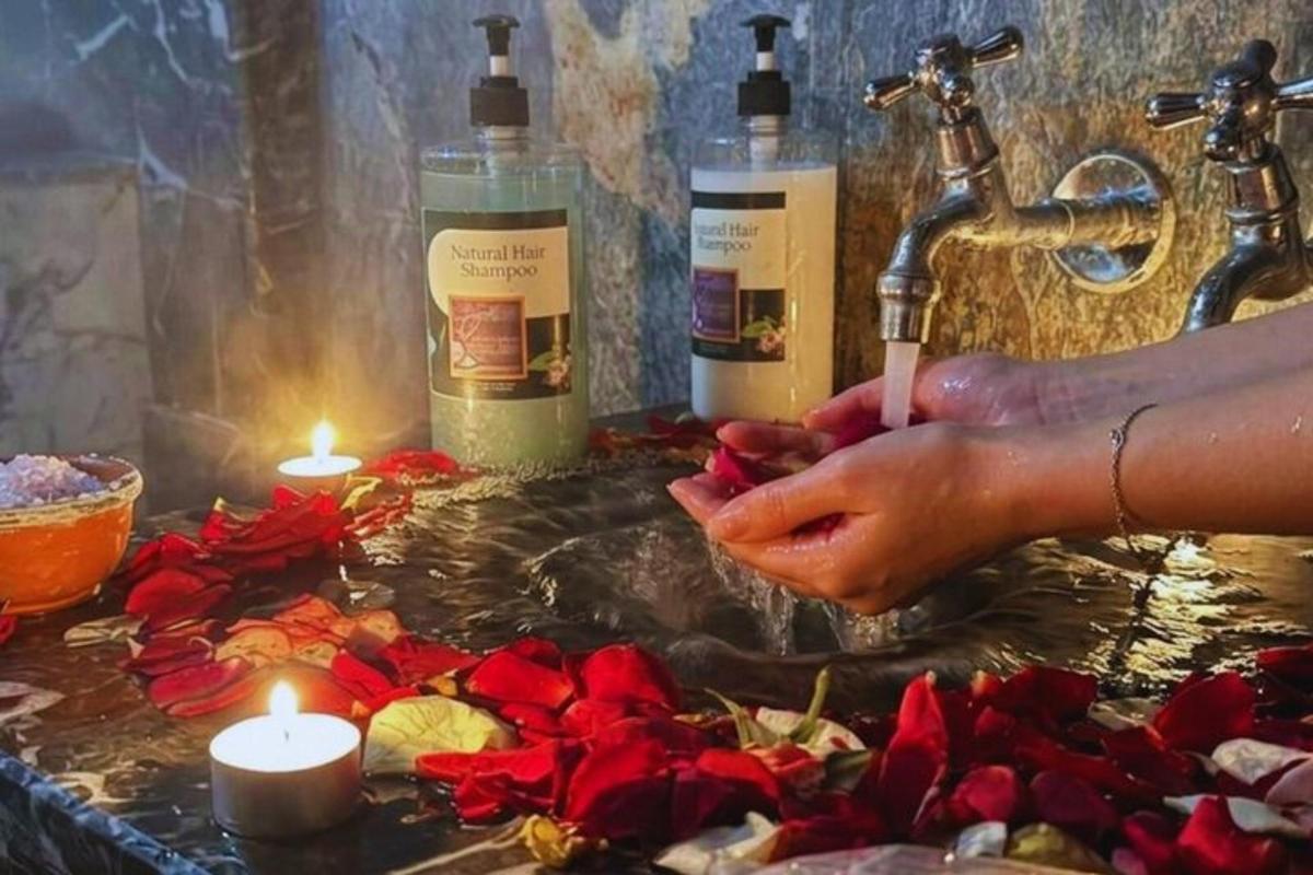 a person is washing their hands in a sink with candles
