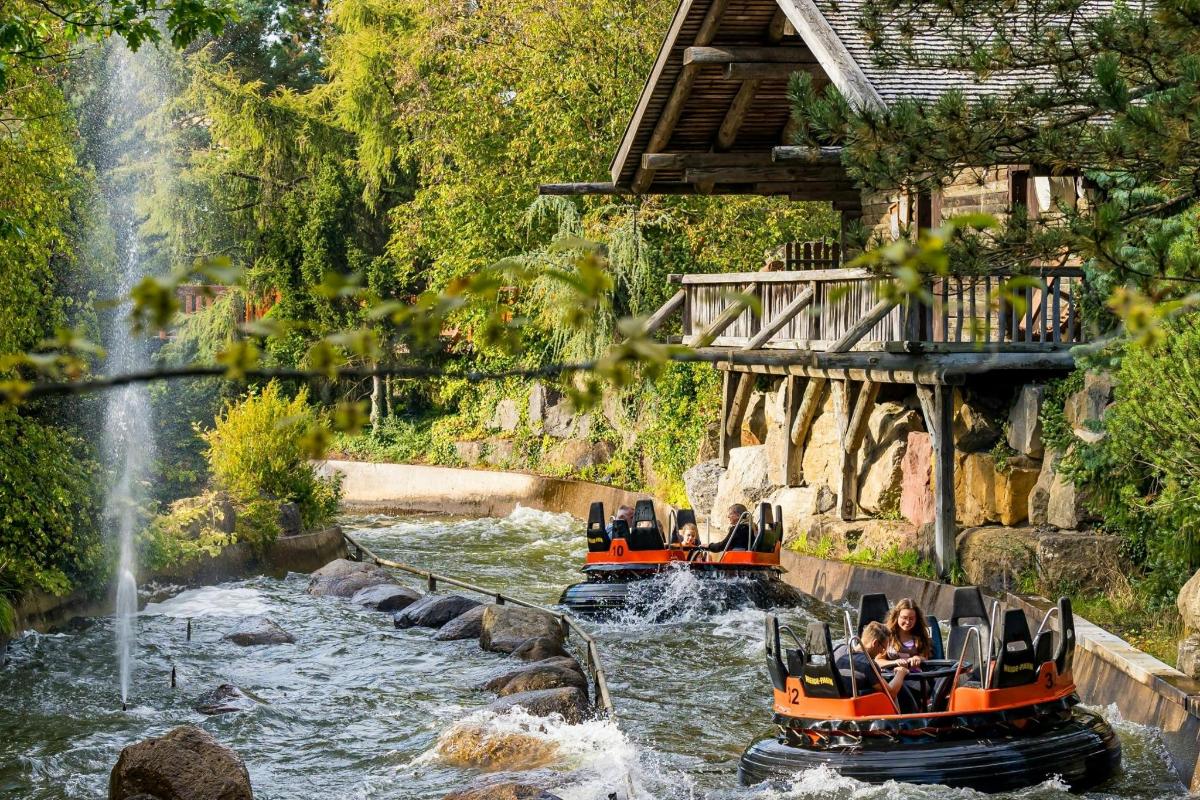 two boats in the water near a waterfall