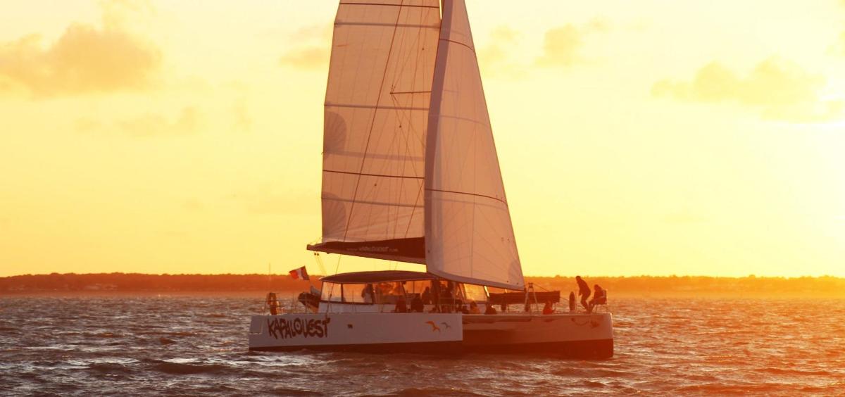 a sail boat in the water with people on it