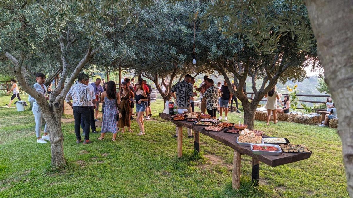 a group of people standing around a table with food on it