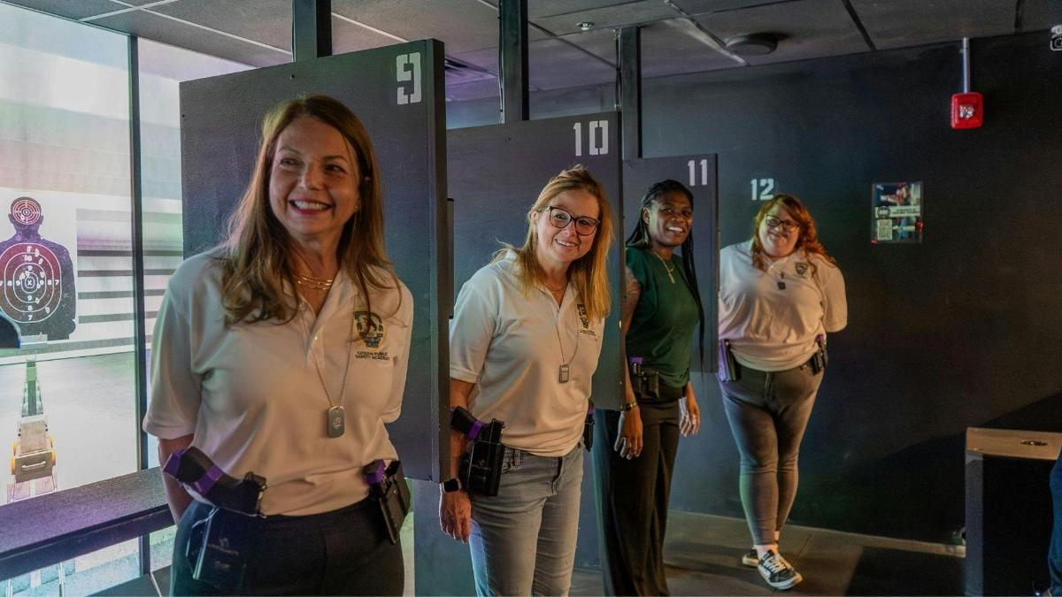 um grupo de pessoas em pé em frente a uma parede de vidro