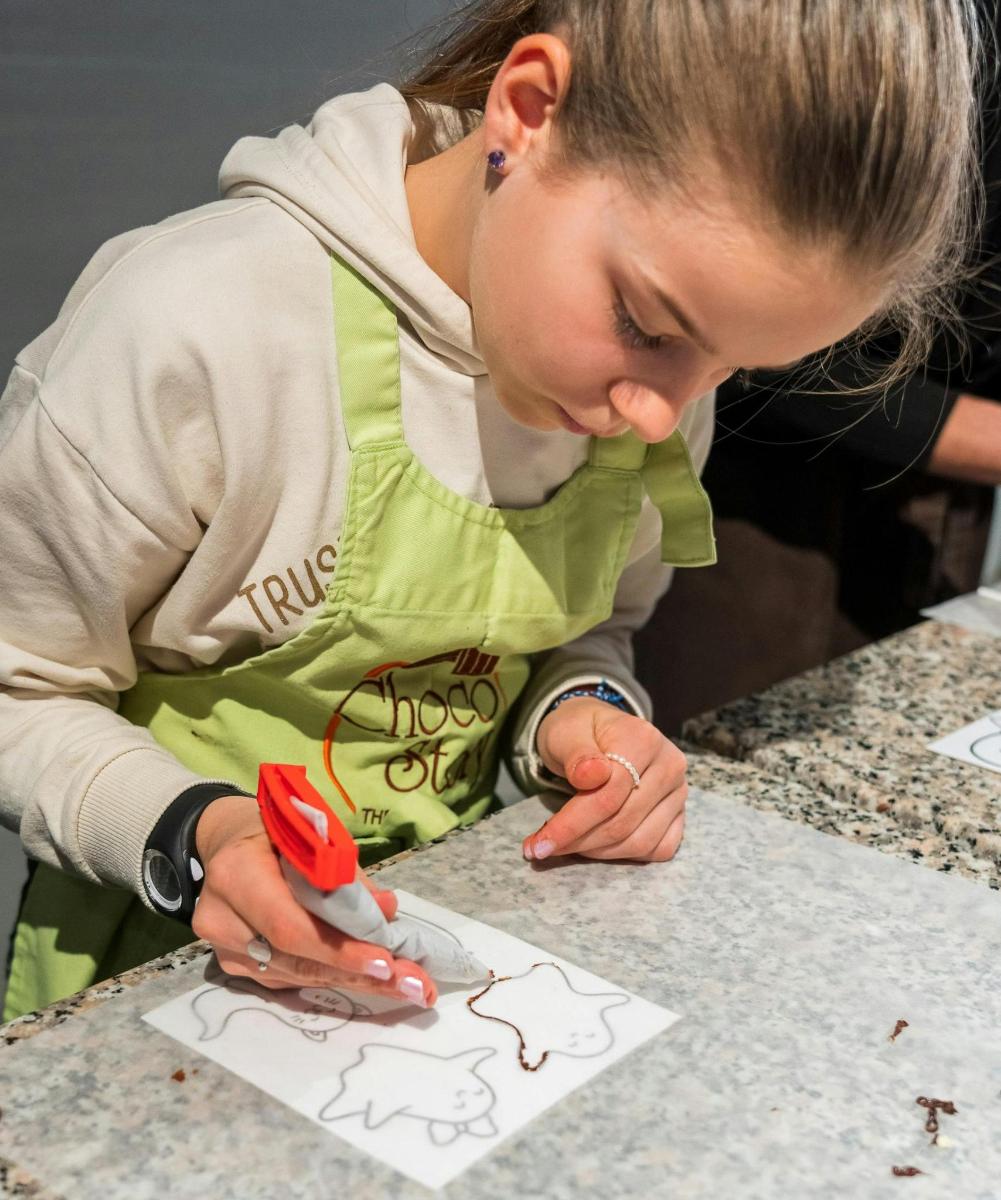 a young girl cutting a piece of paper with scissors