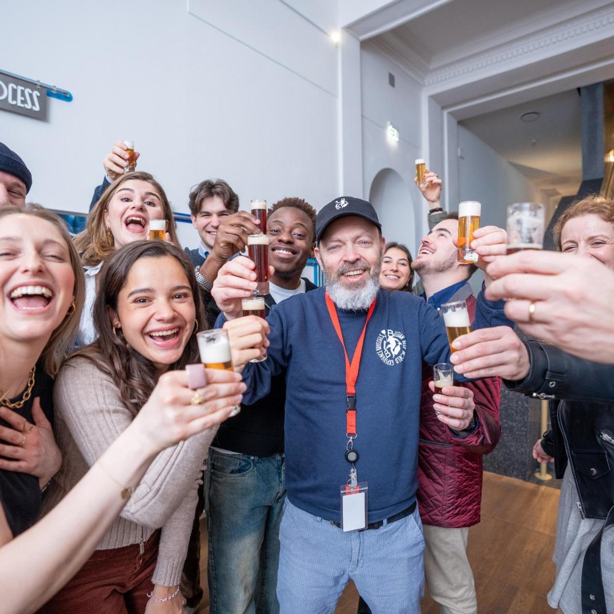a group of people holding up glasses of beer