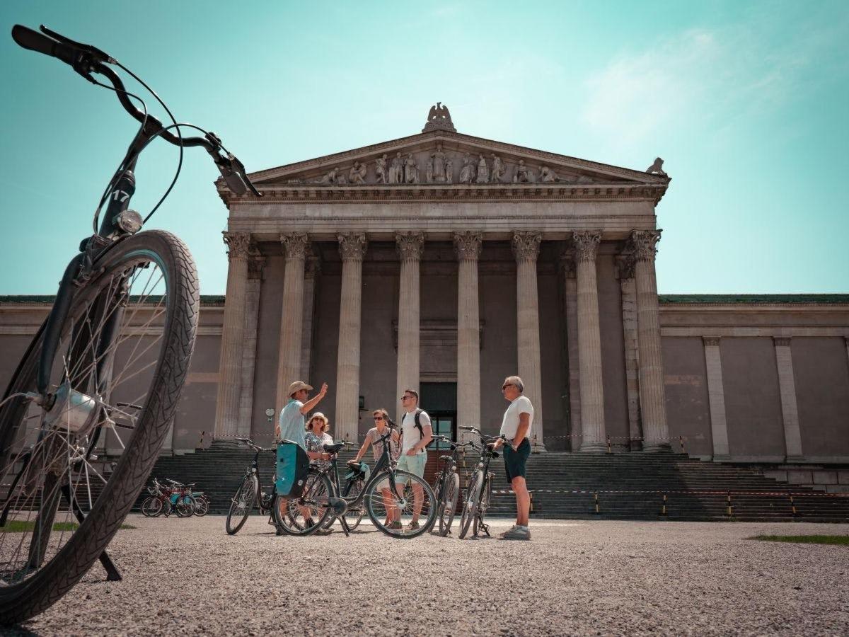 a group of people standing in front of a building with bikes