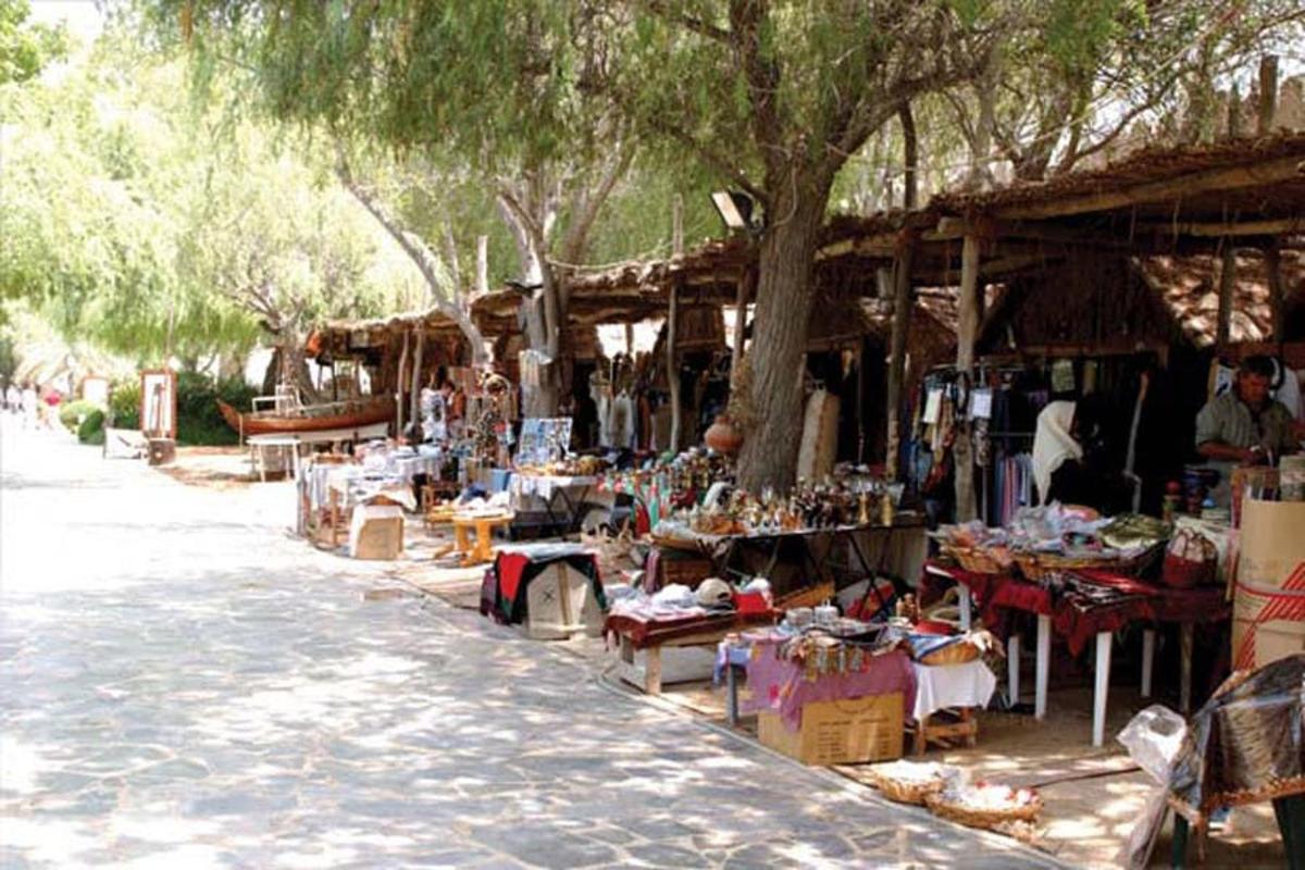 an outdoor market with tables and chairs and trees