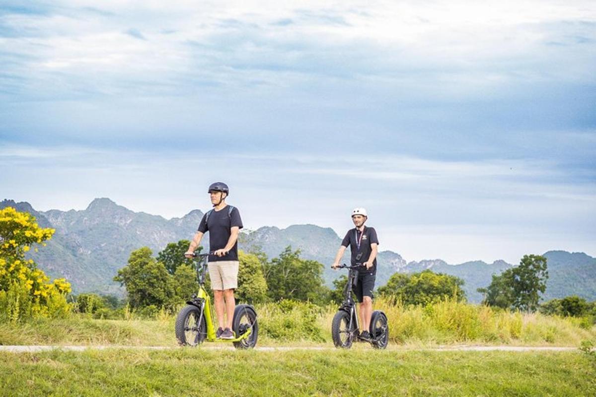 two men riding bikes on a dirt road