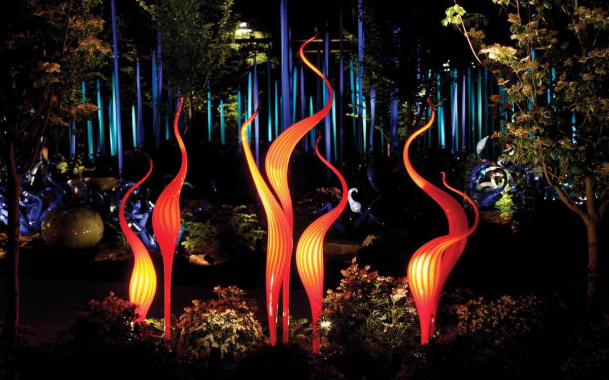 a group of fire sculptures in a garden at night