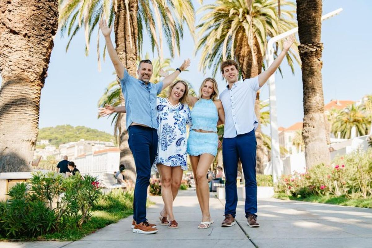 a group of people walking down a sidewalk with their hands in the air