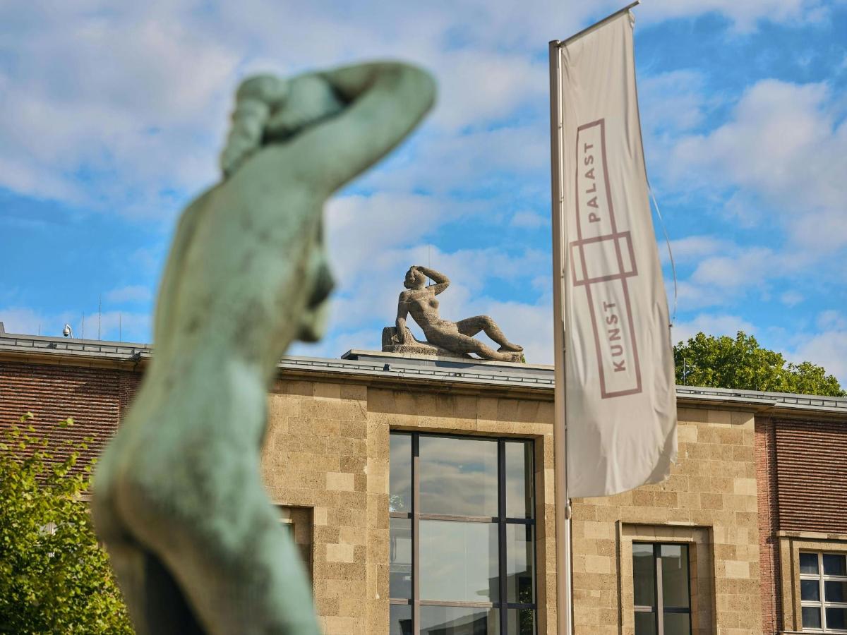 a statue in front of a building with a sign
