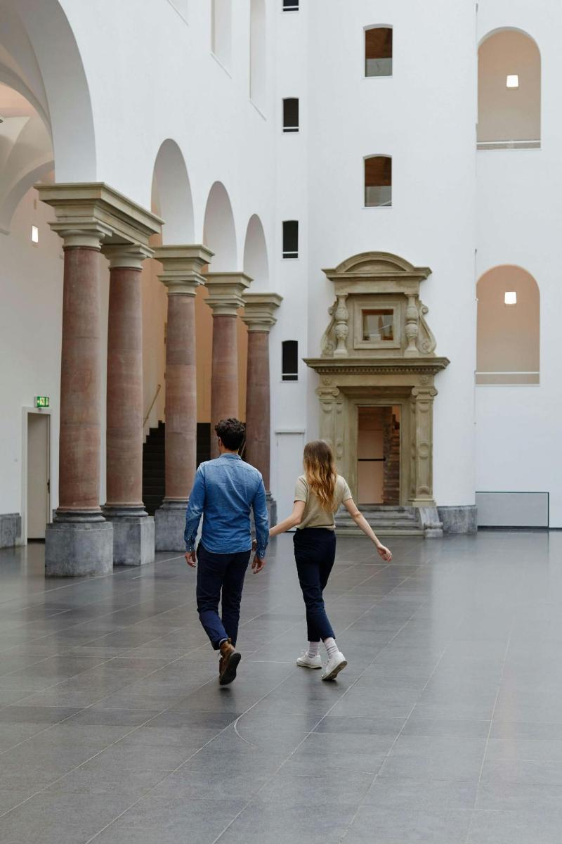 a man and a woman walking through a building