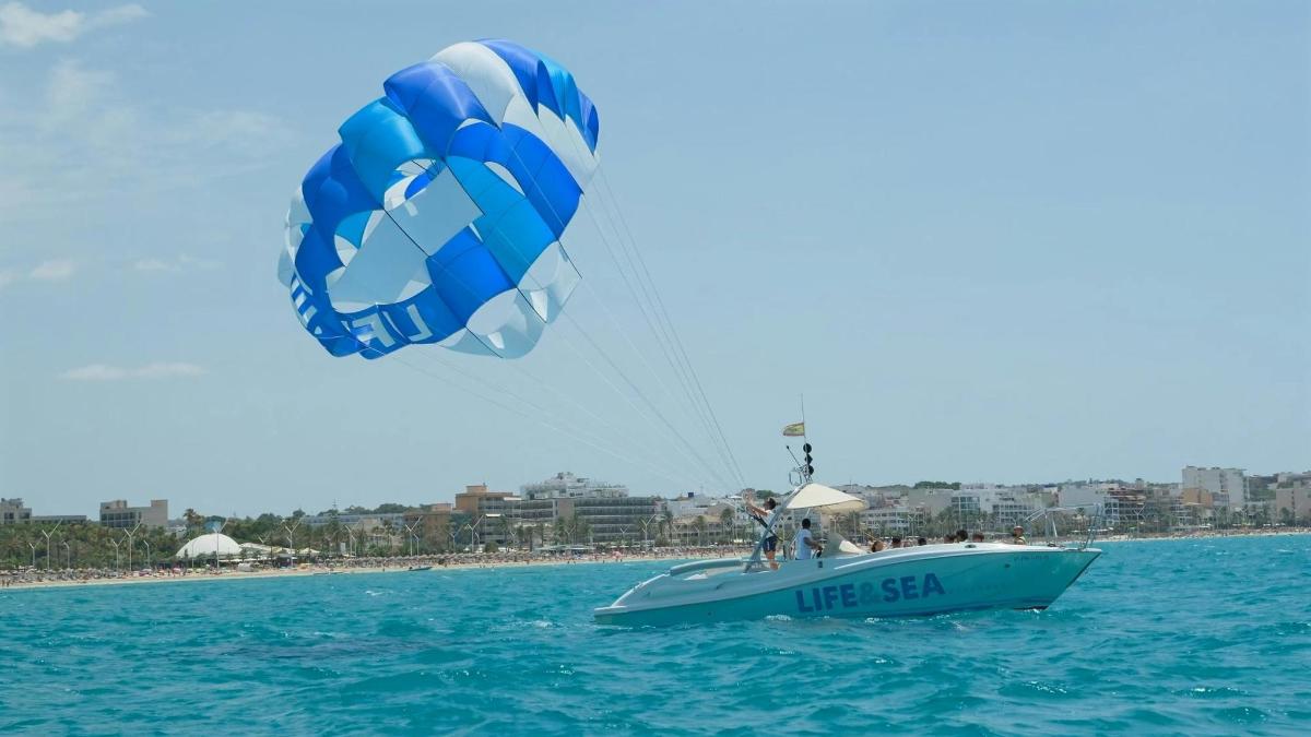 a person on a boat in the water with a kite