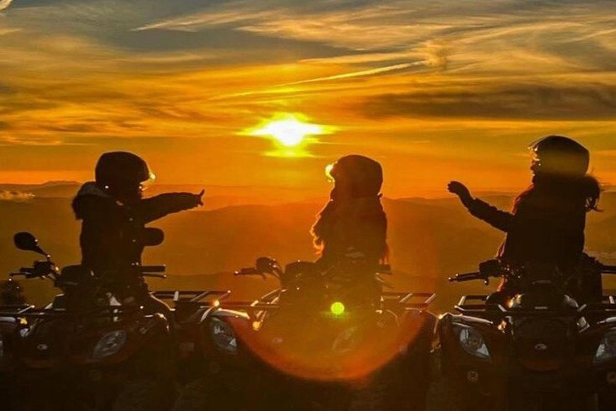 a group of three people riding motorcycles at sunset