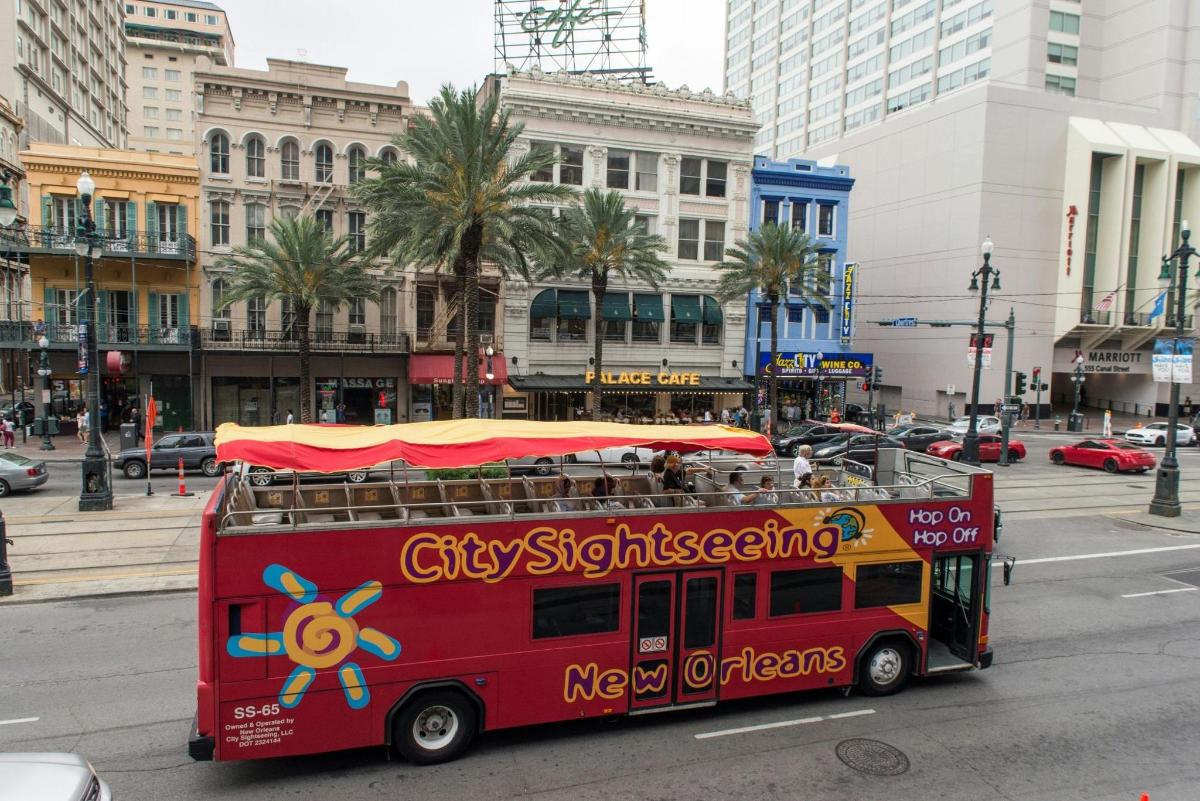 a red double decker bus driving down a city street