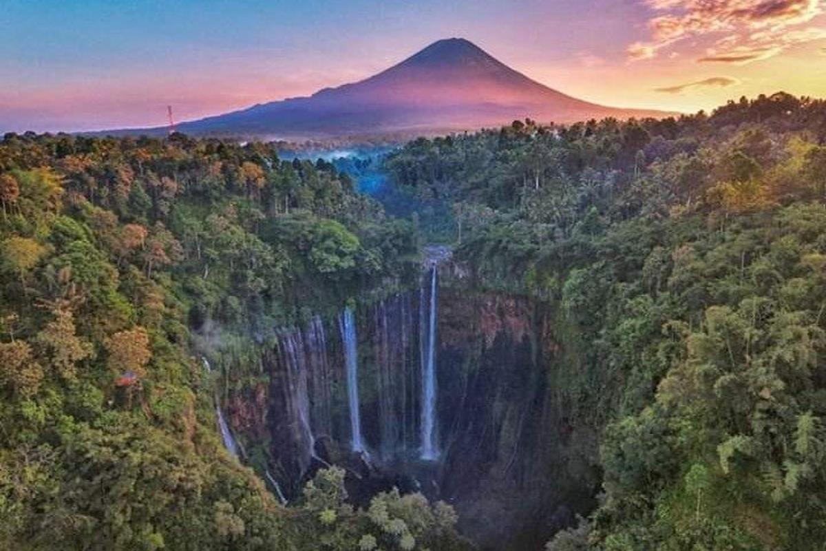 a mountain with a waterfall in the middle of a forest