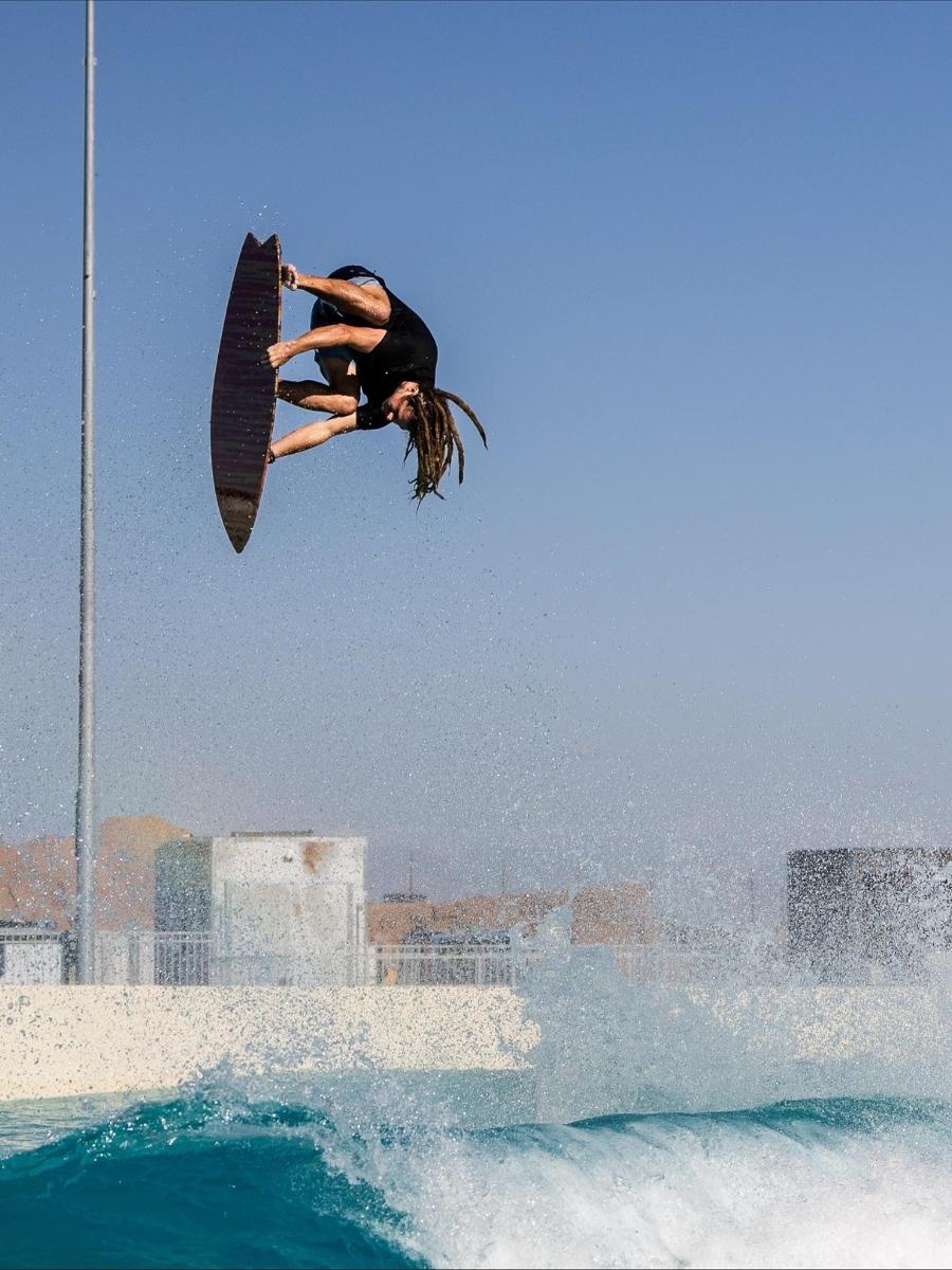 a person on a surfboard in the air over the water