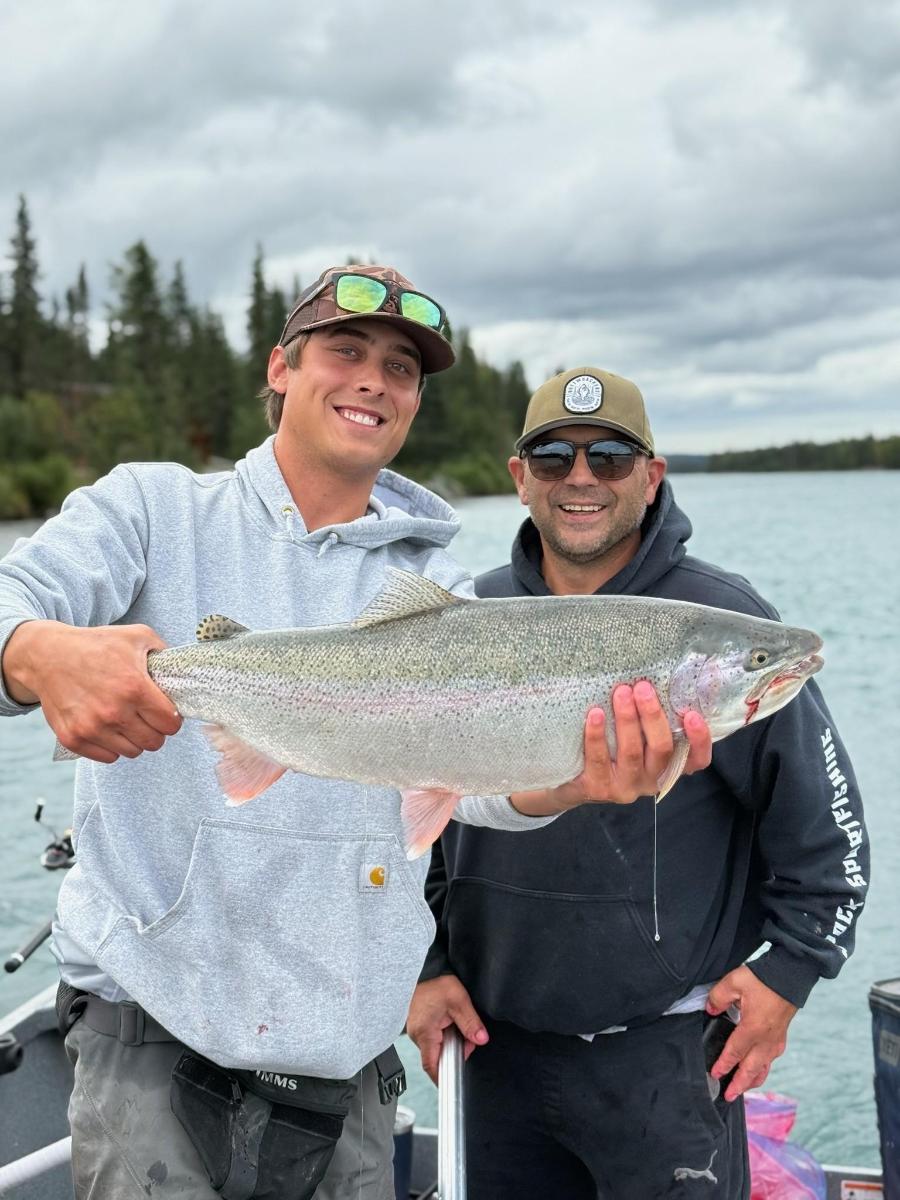 two men holding a large fish on a boat