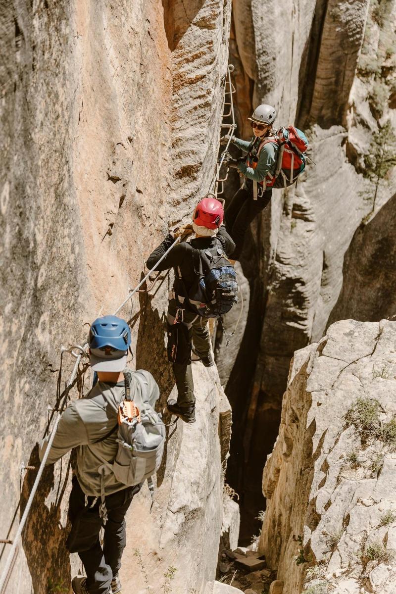 a group of people climbing up a steep canyon