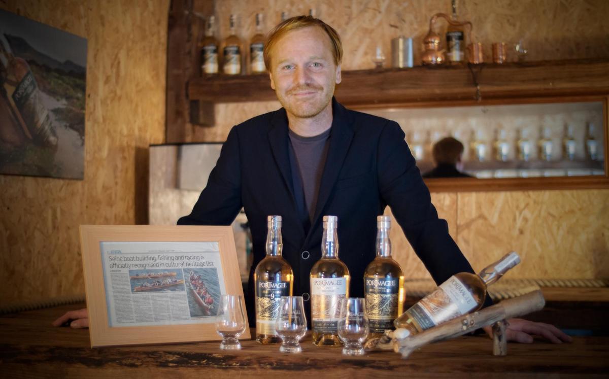 a man standing behind a bar with bottles of wine