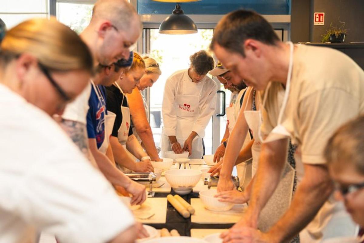 a group of people standing around a table preparing food