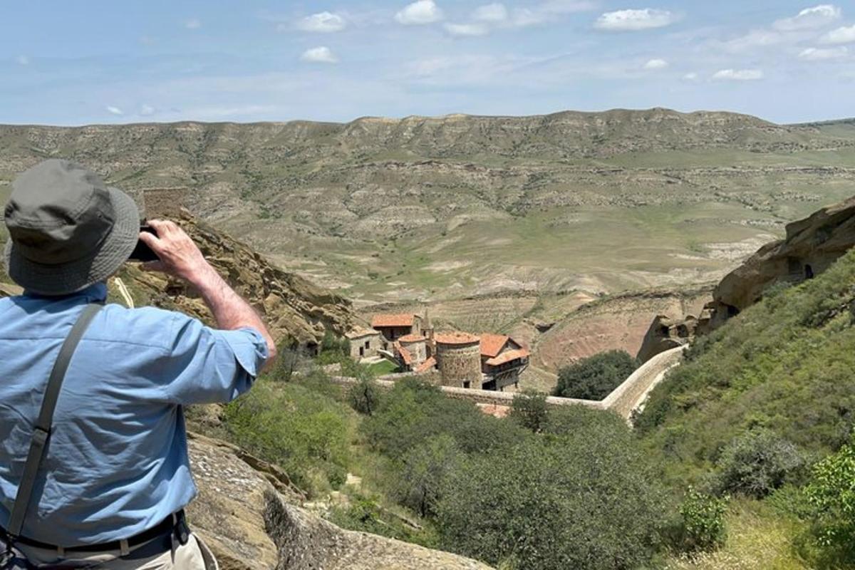 a man standing on a mountain taking a picture