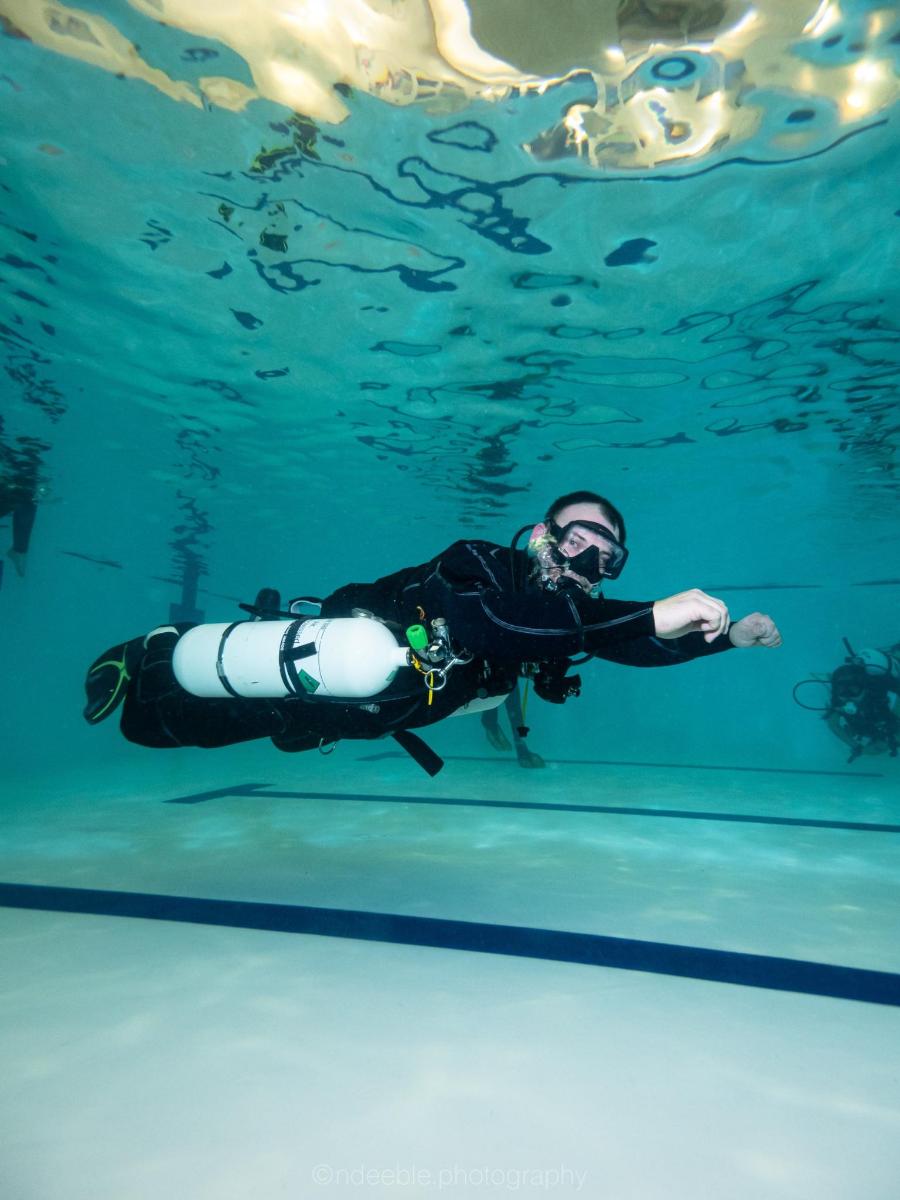 a diver swimming under water in a pool