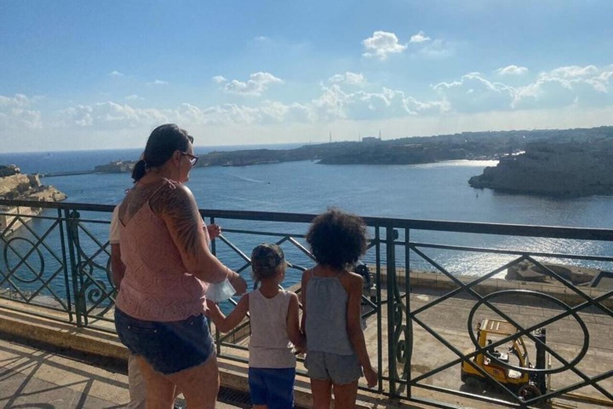 a woman and two children standing on a balcony overlooking a river