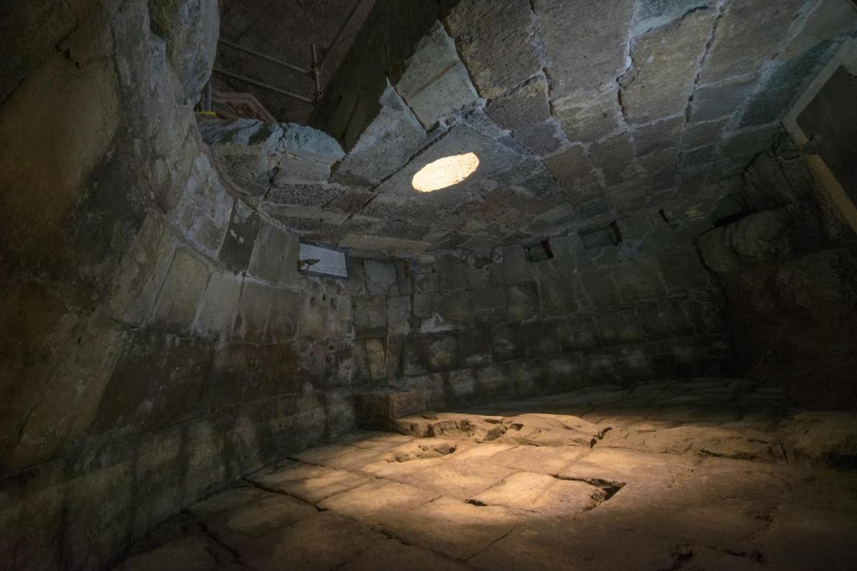 an attic room with a light in a stone wall