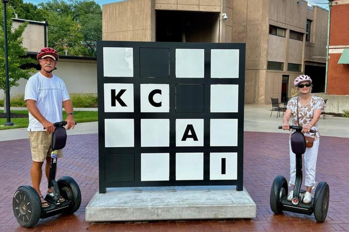 a man and a woman riding segways in front of a sign