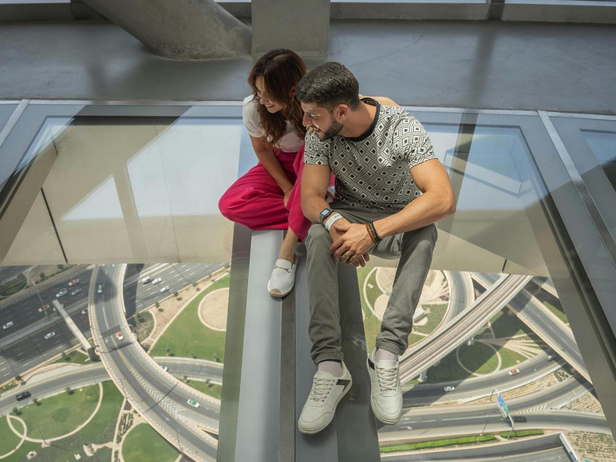 a man and a woman sitting on top of a glass tower