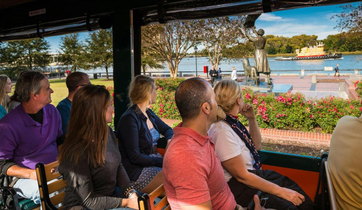a group of people sitting on a bus looking at the water