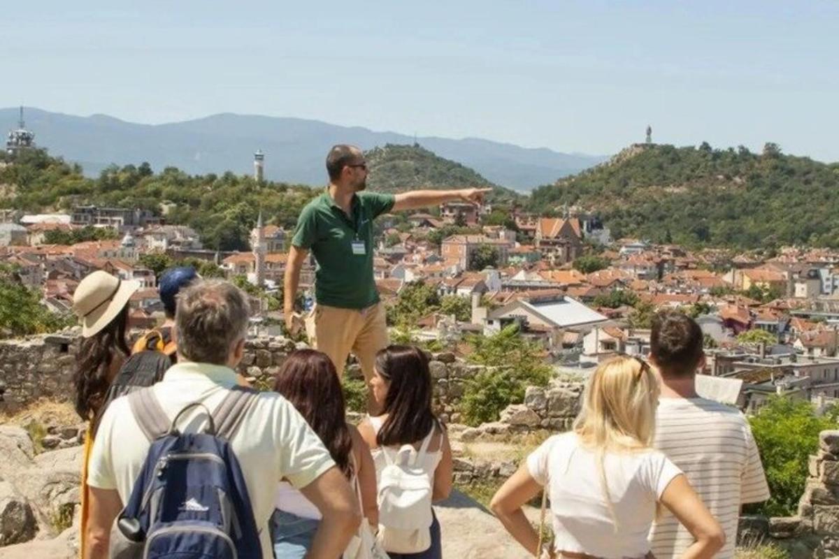 a man standing on top of a hill with a group of people