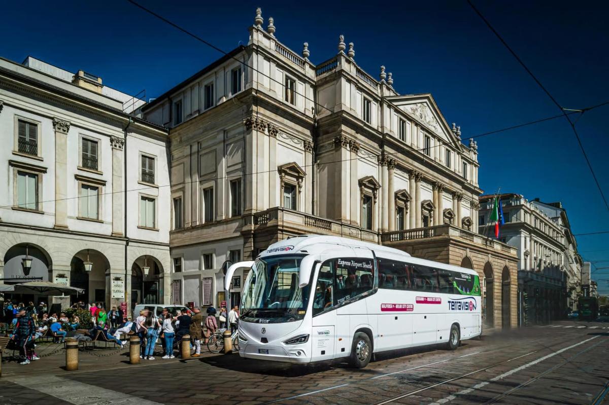 a white bus parked in front of a building