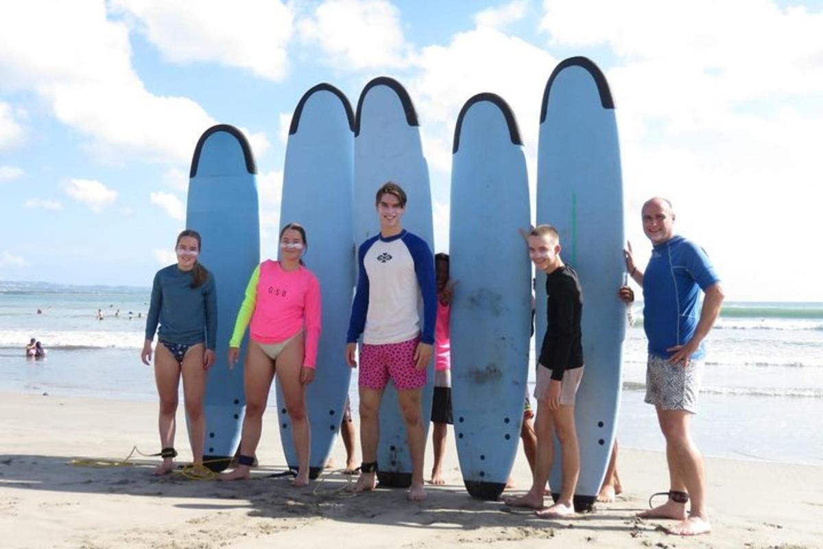 a group of people standing on the beach with surfboards