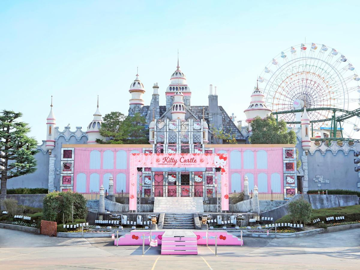 a large pink building with a ferris wheel in the background
