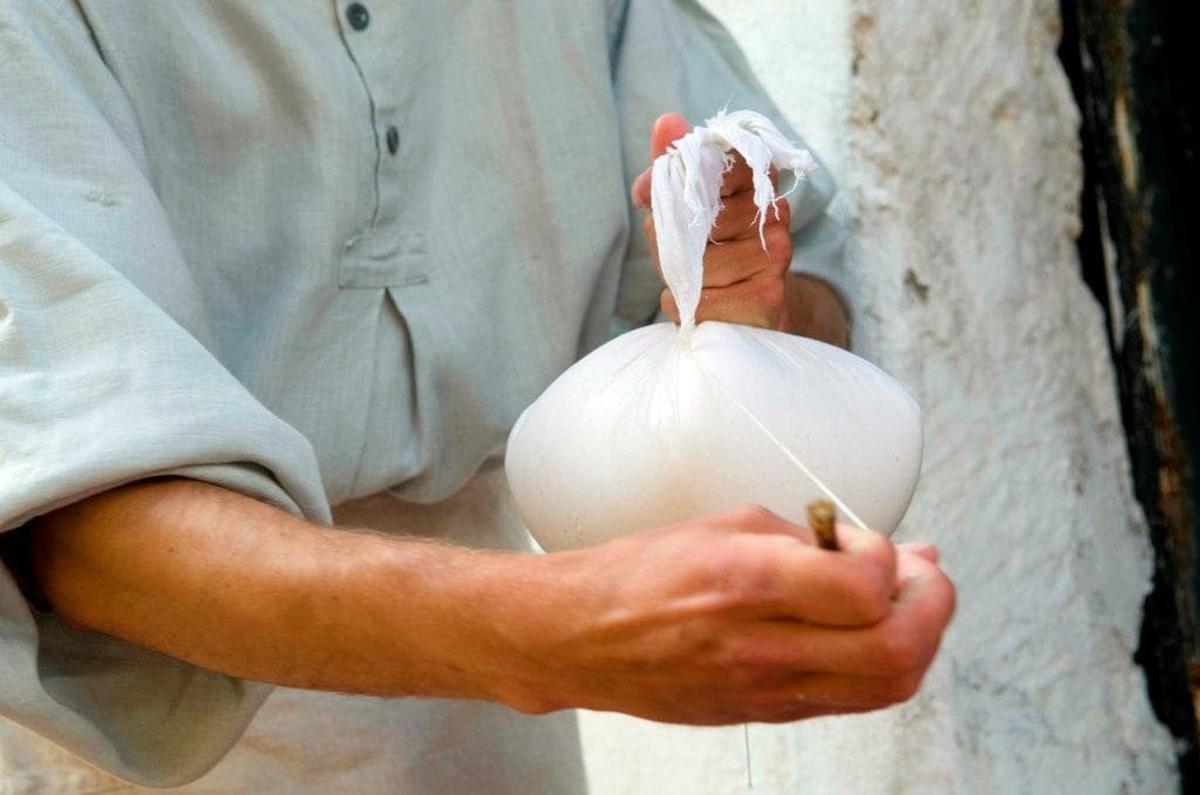 a man holding a onion with a plastic wrap on it