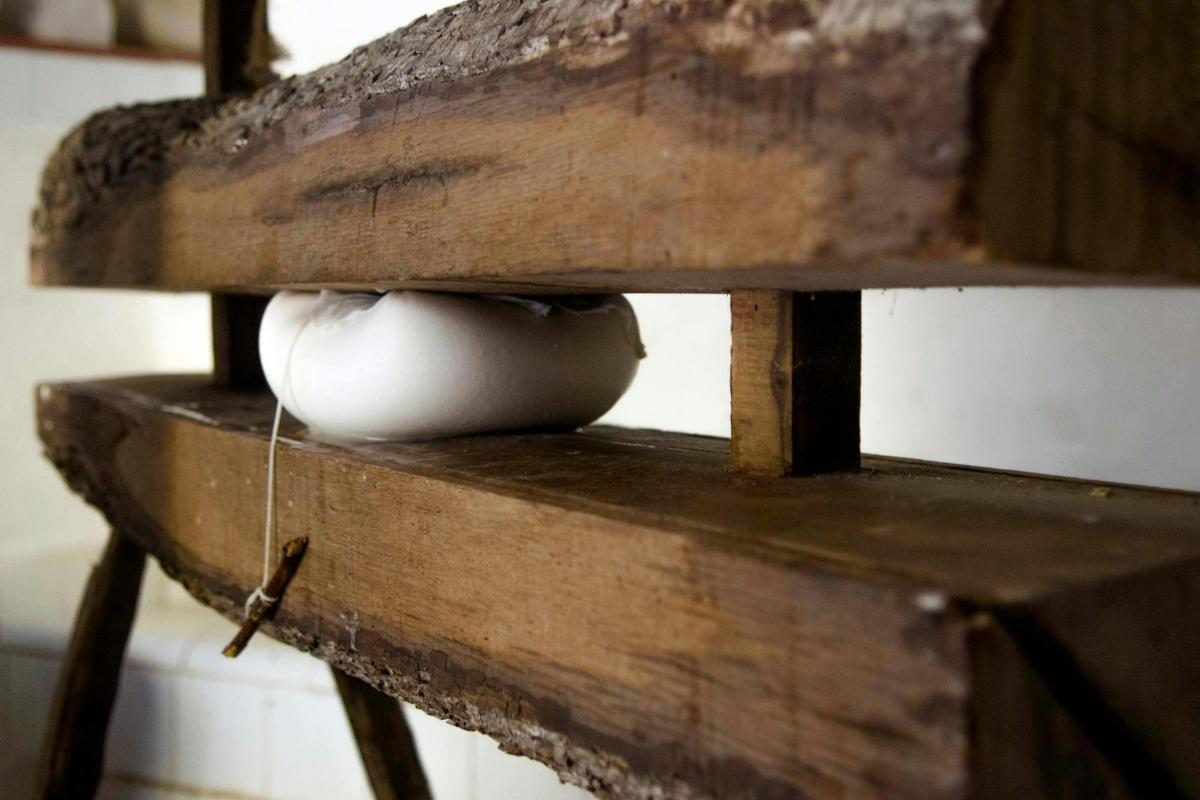 a white vase sitting on top of a wooden table