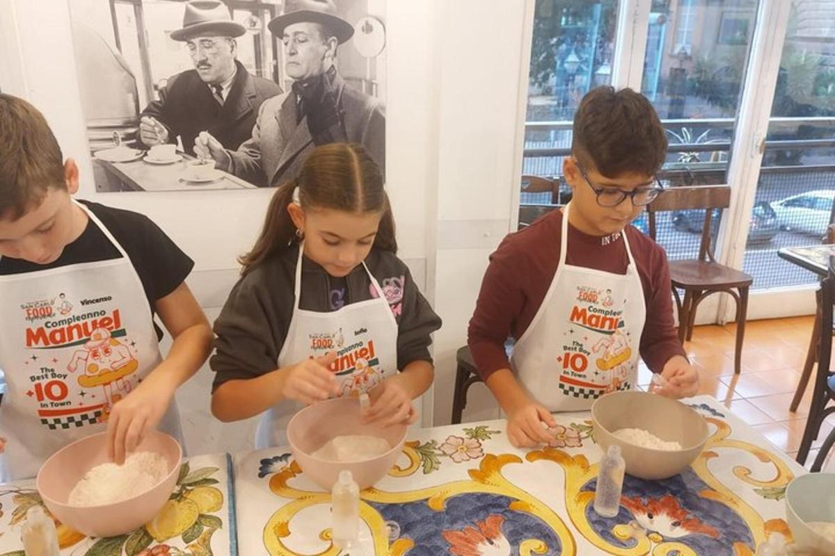 a group of children standing at a table making food