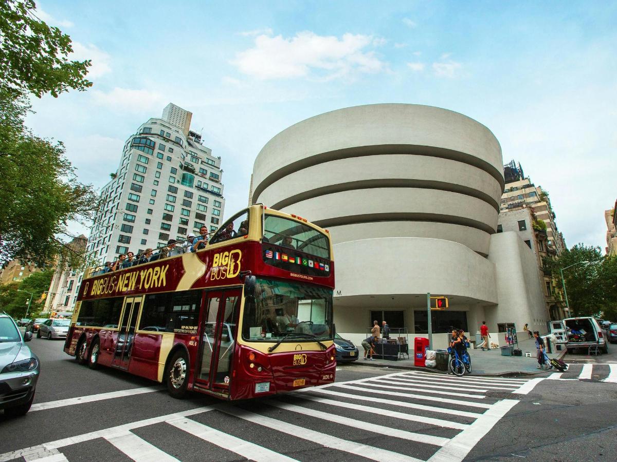 a red double decker bus in front of a building