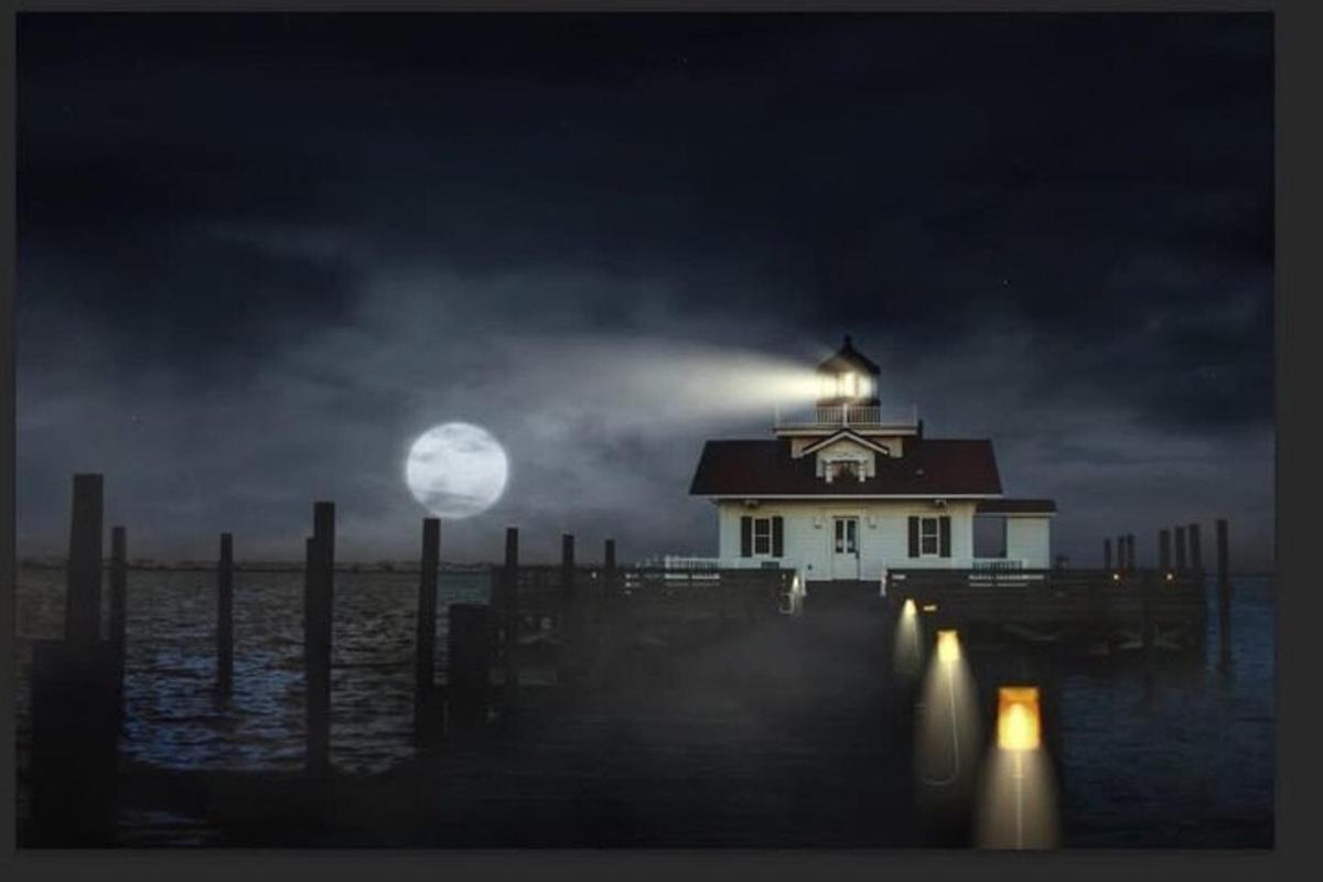 a light house on a pier at night with the moon